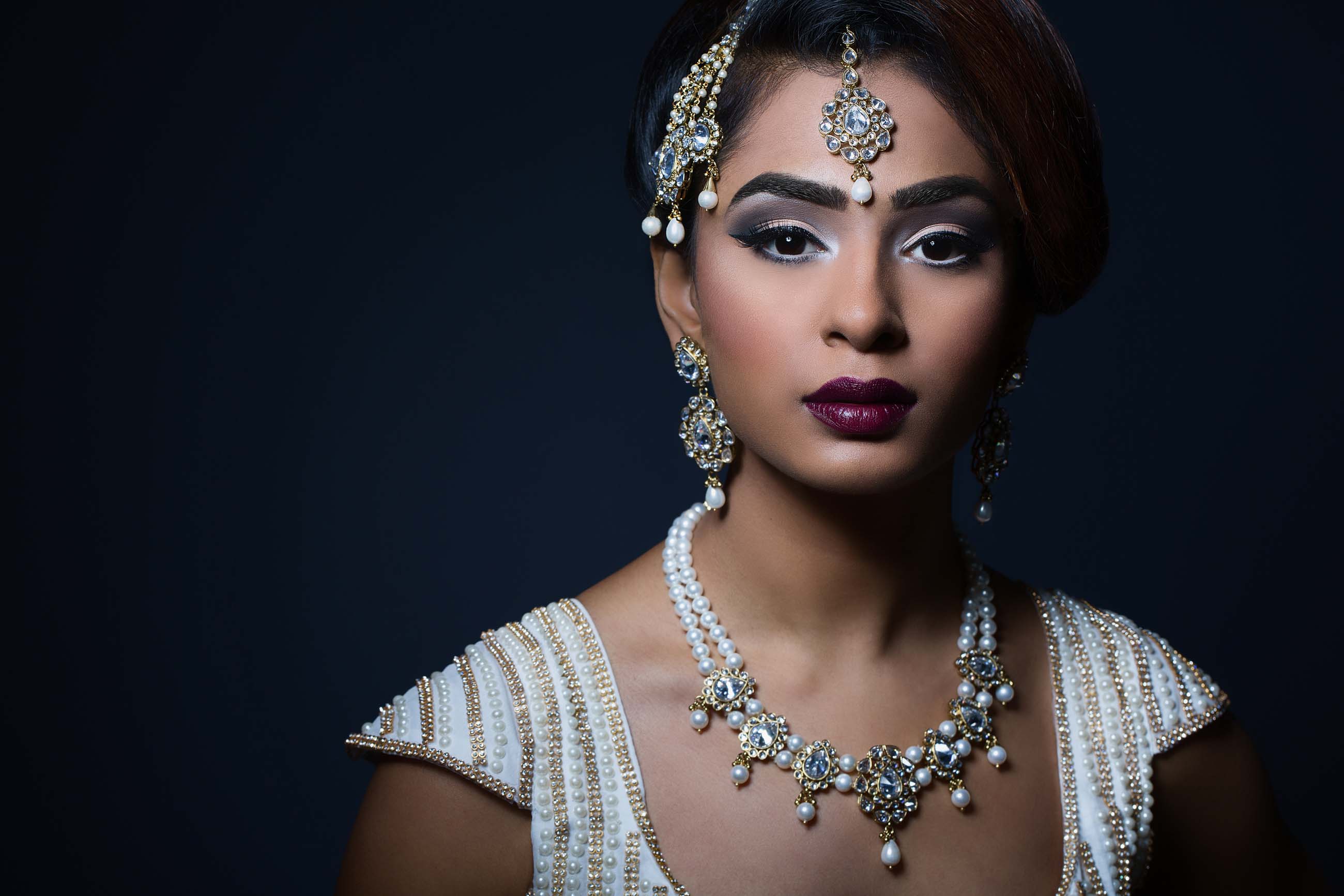 Dark skinned bride wearing white and pearls